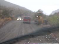 50-construction_grader_is_still_spreading_gravel_in_the_rain_with_heavy_traffic