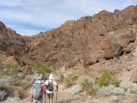 57-1215-Laszlo_and_Kay_hiking_back_up_drainage,climb_up_and_then_back_to_saddle_to_left