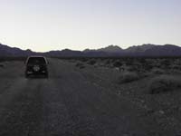 01-travelling_up_dirt_road_from_Valley_of_Fire_Hwy-Muddy_Peak_in_middle_distance