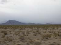 40-looking_west_from_Hwy_95-Mt._Charleston_is_out_there_somewhere
