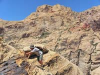 46-Mike_scrambling_back_up-we_found_climbing_bolts_and_caribiners_in_rock_below-class_5-time_to_abort