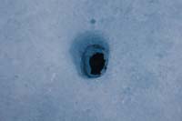 040-glacial_feature-ice_melt_reveals_rock_exposed_to_sun,warms,melts_ice_sinking_into_glacier