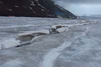 043-glacial_feature-water_cutting_channel_in_ice-snowcoach_staging,lots_of_diesil_exhaust